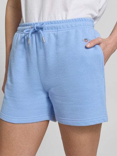 Frauenmodel trägt Sweatshorts mit Eingrifftaschen und Label-Stitching von Gant aus Baumwoll-Mix, Regular-Fit, Nahaufnahme Oberkörper.