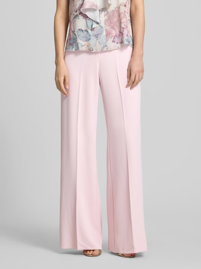 Frauenmodel trägt Stoffhose mit Bügelfalte von Rinascimento in zartem Rosa, weiter Beinverlauf, glatte Textur, Nahaufnahme Oberkörper. Material-Mix mit Stretch-Anteil und Wide Leg Fit sichtbar.