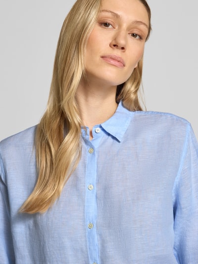 Vrouwenmodel draagt lichte blauwe Hemdbluse uit puur linnen met Kentkraag, regular fit, knoopsluiting, sportmanchetten, model 'MIRA' van 0039 Italy, detailopname bovenlichaam.