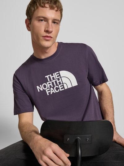 Männermodel trägt Regular Fit T-Shirt mit Logo-Print Modell 'Evolution' von The North Face aus Baumwoll-Mix, Nahaufnahme Oberkörper.