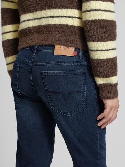 Mannenmodel draagt Modern Fit Jeans met steekzakken Model 'Mitch' van JOOP! Jeans, katoenmix met stretch, labeldetail, detailopname rugaanzicht.
