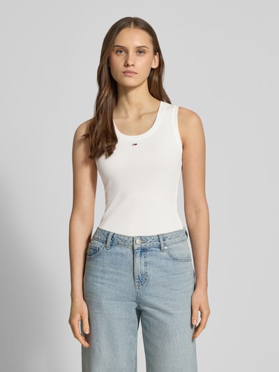Vrouwenmodel draagt 'Slim Fit Tank Top uit katoenmix' van Tommy Jeans, effen kleuren, slim fit, logodetail, fijnrib, U-hals, brede bandjes, katoenmengsel. Ganzichaansicht van voren.