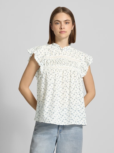 Frauenmodel trägt Regular Fit Blusentop aus reiner Baumwolle Modell 'KATTI' von Only im Florales-Allover-Muster mit Rüschenkragen, Popeline-Struktur, Rundhals-Ausschnitt, 1-Knopf-Verschluss, Kurzarm, helle Farben, Ganzkörperansicht von vorne.