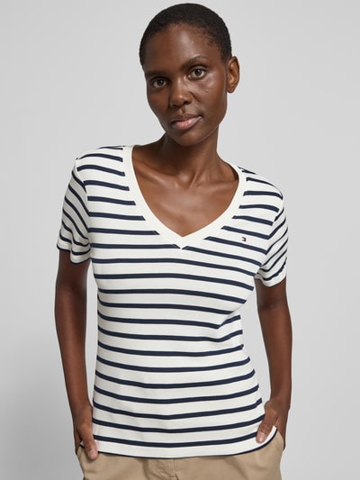 Kobiece model prezentuje Slim Fit T-Shirt aus reiner Baumwolle von Tommy Hilfiger, efekt: jednolity kolor, krój slim fit, wyhaftowane logo, dekolt w serek, krótki rękaw, wykończenie materiału: dżersej, materiał: bawełna, góra w paski, zdjęcie: zbliżenie górnej części ciała z przodu.