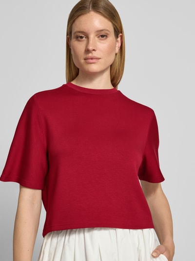 Kobieta nosi damski t-shirt Relaxed Fit T-Shirt mit Rundhalsausschnitt model 'Maelee' od MSCH Copenhagen, okrągły dekolt, rękaw o dł. 1/2, długość tyłu w rozmiarze XS/S: 53 cm, widok na górną część ciała z przodu