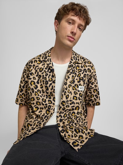 Männermodel trägt Relaxed-Fit Freizeithemd aus reiner Baumwolle Modell 'ZEKE' von Only & Sons mit braun-schwarzem Leo-Muster, Nahaufnahme Oberkörper. Herren Freizeithemd von Only & Sons.