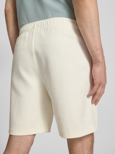 Męski model nosi Shorts mit Label-Stitching mit elastischem Bund od CHAMPION, bawełniana mieszanka, krój regular fit, szerokość w rozmiarze M: 37 cm, długość nogawki wewnętrznej w rozmiarze M: 42 cm, widok całej sylwetki z tyłu.