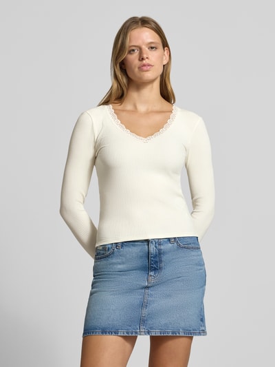 Frauenmodel trägt Slim Fit Langarmshirt aus Baumwoll-Mix Modell 'SARA SHARAI' von ONLY, cremefarben, strukturierte Oberfläche, Ganzkörperansicht von vorne, Damen Langarmshirt von ONLY.