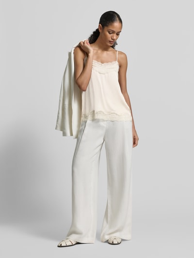 Frauenmodel trägt Regular Fit Blusentop mit Spitzenbesatz von Jake*s Collection, semitransparentes Satin-Design, Spaghettiträger, Ganzkörperansicht von vorne.