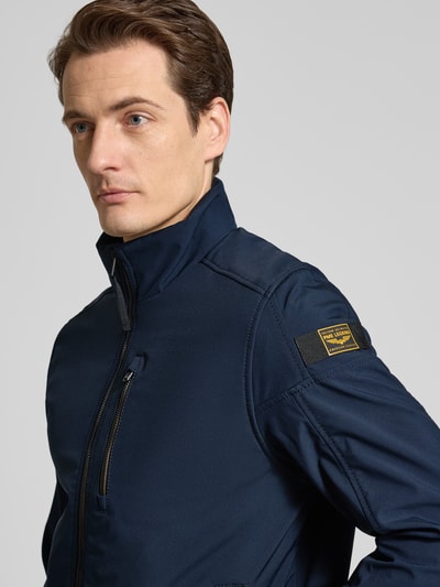 Męski model nosi granatową Jacke mit Stehkragen Modell 'SKYGLIDER' od PME Legend, materiał z domieszką stretchu, krój regular fit, zamek, kieszenie boczne, zbliżenie na górną część ciała, kontekst: długość tyłu 71 cm, szerokość ramion 46 cm, szerokość klatki piersiowej w rozmiarze M: 56 cm, długość rękawa 68 cm