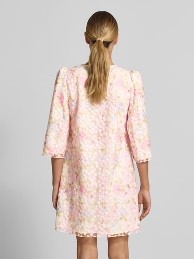 Frauenmodel trägt Cocktailkleid mit V-Ausschnitt Modell 'LEANNA' von YAS, A-Linie, Minikleid mit 3/4-Arm, blumiges Muster, Rückenlänge 87 cm, Brustweite 46 cm, Ärmellänge 48 cm, Ganzkörperansicht Rückansicht.
