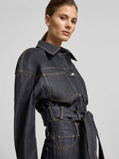 Vrouwenmodel draagt Oversized Jeansjacke aus Baumwoll-Mix Modell 'GALATA' van HUGO in effen donkerblauw, lange mouwen, borstzak, bindceintuur, knoopsluiting, unie kleur, katoenmix, nahaufnahme bovenlichaam.