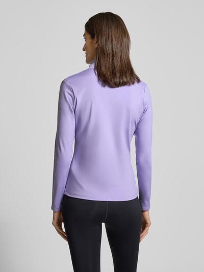 Frauenmodel trägt Motion Jacket mit Logo-Print Modell 'EMEA' von Under Armour in Flieder, körpernaher Schnitt, Stehkragen, Ganzkörperansicht Rückansicht, Kontext: Damen Motion Jacket, Reißverschluss, seitliche Reißverschlusstaschen, Rückenlänge 60 cm, Schulterbreite 36 cm, Brustweite 42 cm, Ärmellänge 60 cm.