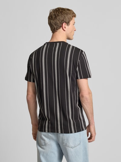 Männermodel trägt Regular Fit T-Shirt aus reiner Baumwolle von Tommy Jeans, Optik: Allover-Muster, Ganzkörperansicht Rückansicht.