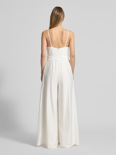 Kobiece modelka nosi Jumpsuit mit Wasserfall-Ausschnitt und Spaghettiträgern od Hey Kyla, satyna, taliowany krój, wiązany pasek, zapięcie na haftkę i zamek błyskawiczny, długość tyłu w rozmiarze 36: 39 cm, szerokość w rozmiarze 36: 33 cm, całkowita długość w rozmiarze 36: 154 cm, długość wewnętrzna nogawki w rozmiarze 36: 84 cm, widok całej sylwetki z tyłu.