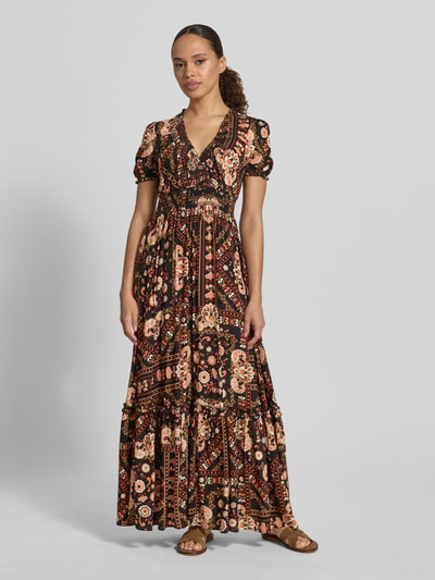 Frauenmodel trägt Maxikleid aus Viskose mit V-Ausschnitt von Apricot, Taillierter Schnitt, Smok-Detail, Rüschenärmel, Volantsaum, florales Muster, Rückenlänge bei Größe S 138 cm, Brustweite 44 cm, Ärmellänge 20 cm, Ganzkörperansicht von vorne.