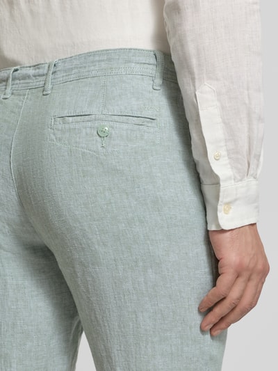 Männermodel trägt Leinenhose mit Schnürung und Gesäßtaschen von MCNEAL in hellem Grün, reine Leinenstruktur, Nahaufnahme Rückansicht.