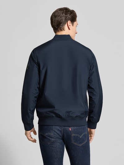 Männermodel trägt Jacke mit Stehkragen Modell 'clay' von Matinique in Dunkelblau, Regular-Fit, Rückenansicht, glatte Textur. Kontext: Herren Jacke, Stehkragen, Reißverschluss, Eingrifftaschen mit Druckknopfverschluss, Rückenlänge 67 cm, Schulterbreite 45 cm, Brustweite 56 cm, Ärmellänge 66 cm.