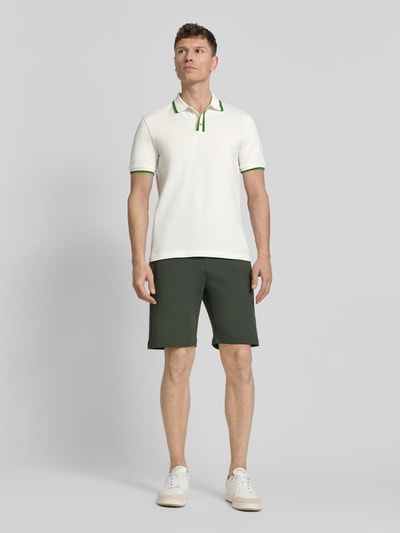 Männermodel trägt Regular Fit Poloshirt mit Kontraststreifen von PAUL SMITH aus Baumwoll-Elasthan-Mix, Knopfleiste, Ganzkörperansicht von vorne.