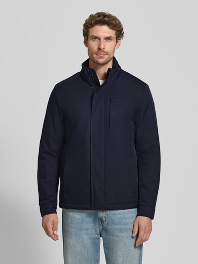 Männermodel trägt Jacke mit verdecktem Reißverschluss und Eingrifftaschen von Geox in Dunkelblau, glatte Textur, Ganzkörperansicht von vorne. Rückenlänge 71 cm, Schulterbreite 50 cm, Brustweite 58 cm, Ärmellänge 69 cm, Regular Fit, Stehkragen.