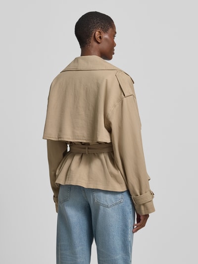 Männermodel trägt Boxy Fit Trenchcoat-Jacke aus Baumwoll-Leinen-Mix Modell 'ACLUNDA-1-W' von HUGO, efekt: jednolity kolor, krój: pudełkowy krój, kołnierz z połami, listwa guzikowa 2-rzędowa, pasek, aplikacja: pagony, rękaw: długi rękaw z patkami, kieszenie: wpuszczane kieszenie boczne, materiał: mieszanka bawełny i lnu. Ganzkörperansicht Rückansicht.