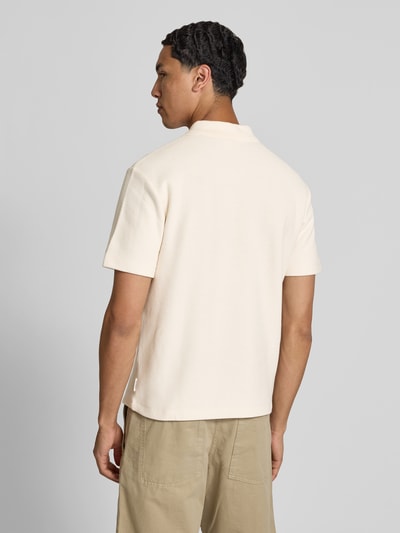 Männermodel trägt Regular Fit Poloshirt aus Baumwolle von Closed in Beige mit Strukturmuster, kurzärmelig, Ganzkörperansicht Rückansicht.