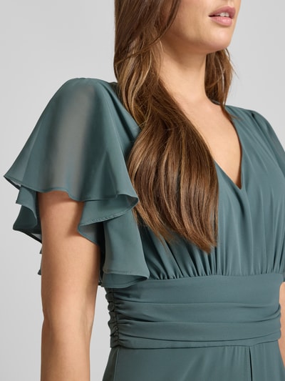 Frauenmodel trägt Jumpsuit mit V-Ausschnitt von Swing in Grün, Material-Mix mit Stretch, taillierter Schnitt, Nahaufnahme Oberkörper.