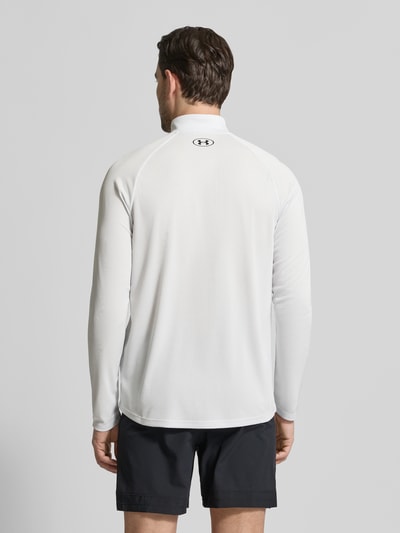 Männermodel trägt Sweatshirt mit kurzem zamkiem błyskawicznym i nadrukiem z logo von Under Armour, prosty krój, stójka, długość tyłu w rozmiarze m 74 cm, długość rękawów w rozmiarze m 64 cm, jasnoszary kolor, gładka tekstura, Ganzkörperansicht Rückansicht