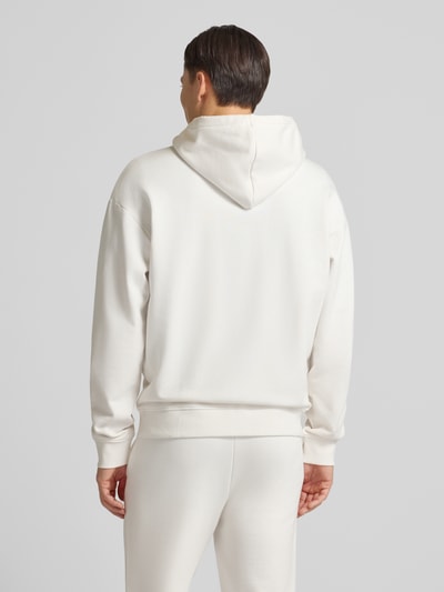 Männermodel trägt Relaxed Fit Sweatjacke aus reiner Baumwolle Modell 'DAPOZIP' von HUGO in Unifarben, Ganzkörperansicht Rückansicht.