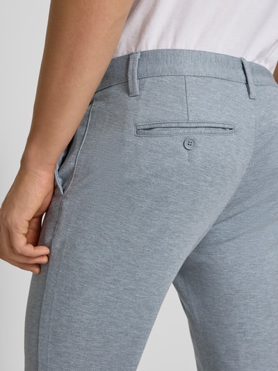 Männermodel trägt Slim Fit Chino aus Viskose-Mix Modell 'MARK' von Only & Sons, efekt: jednolity kolor, melanż, szlufki na pasek, kieszeń z tyłu, zapięcie na guzik i zamek błyskawiczny, mieszanka wiskozy, detaliczna faktura, Ganzkörperansicht Rückansicht