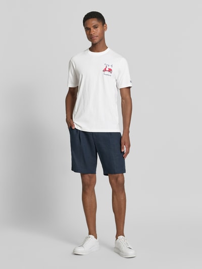 Męski model nosi biały t-shirt z haftami model 'PORTOFINO' od MC2 Saint Barth z bawełny, krój regular fit, okrągły dekolt, długość tyłu w rozmiarze M: 68 cm, widok całej sylwetki z przodu.