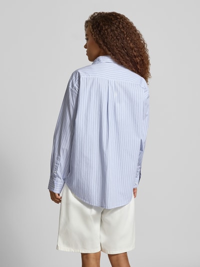 Vrouwenmodel draagt Relaxed Fit blouse met labelstitching Model 'Keene' van Carhartt Work In Progress, puur katoen, overhemdkraag, knoopsluiting, borstzak, ruglengte maat S 78 cm, mouwlengte maat S 56 cm, lichtblauw met witte strepen, gladde structuur, rugaanzicht volledige lengte.