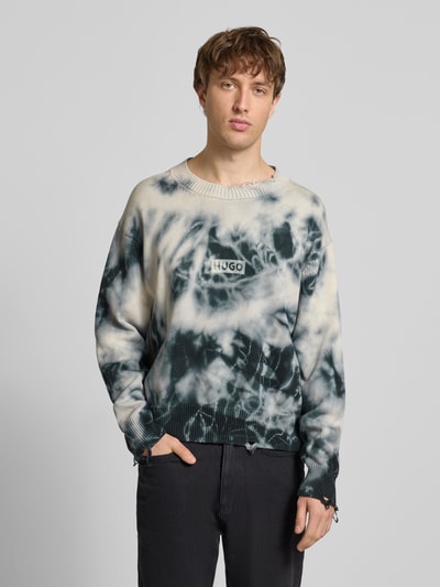 Männermodel trägt Relaxed Fit Pullover aus reiner Baumwolle Modell 'SESTROY' von Hugo Blue mit Batikmuster, Rundhals, Used Look, Ganzkörperansicht von vorne.