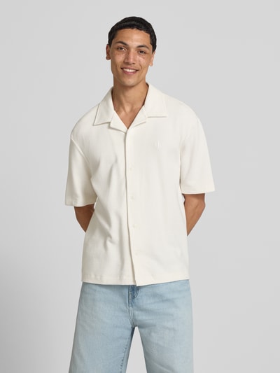 Männermodel trägt Relaxed Fit Freizeithemd aus reiner Baumwolle von Calvin Klein Jeans, Optik: Unifarben, Ärmelform: Kurzarm, Materialverarbeitung: Piqué, Logo-Stitching, Reverskragen, durchgehende Knopfleiste, Ganzkörperansicht von vorne.