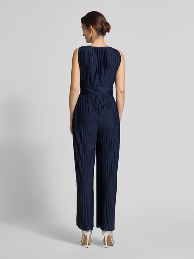 Vrouwenmodel draagt donkerblauwe Jumpsuit met plooien model 'Linnea' van GUIDO MARIA KRETSCHMER WOMAN in satijn, licht getailleerde fit, geheel achteraanzicht.