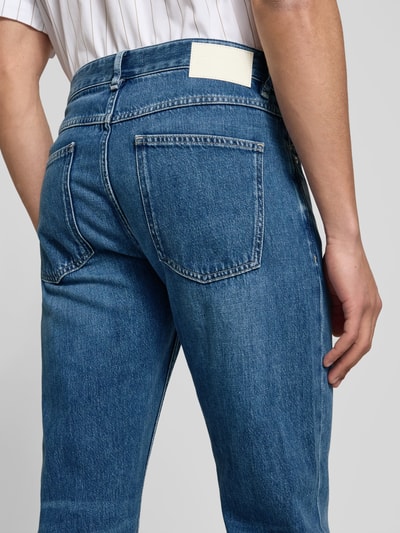 Männermodel trägt Straight Fit Jeans mit Logo-Patch von Closed, reine Baumwolle, 5-Pocket-Design, Detailaufnahme Rückansicht.