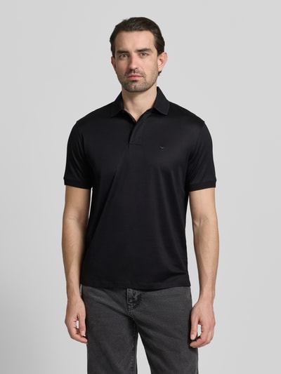 Männermodel trägt Poloshirt mit kurzer Knopfleiste von Emporio Armani in Schwarz, Lyocell-Baumwoll-Mix, Regular Fit, Ganzkörperansicht von vorne.