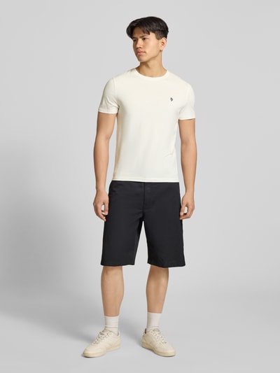 Männermodel trägt Basic Slim Fit T-Shirt mit Flock-Logo auf der Brust von REVIEW, Baumwoll-Viskose-Mix, Rundhalsausschnitt, Herren T-Shirt, Rückenlänge 64 cm, Größe M, Ganzkörperansicht von vorne.