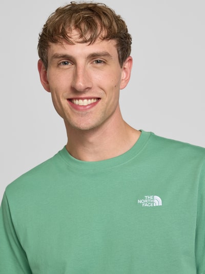Männermodel trägt T-Shirt mit Label-Stitching und Rundhalsausschnitt von The North Face, Baumwoll-Mix, Regular-Fit, Nahaufnahme Oberkörper.