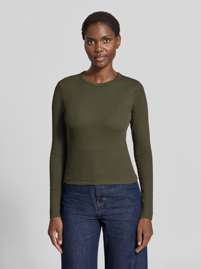 Frauenmodel trägt Slim Fit Langarmshirt aus Baumwoll-Mix Modell 'CHLOE' von VERO MODA, in Olivgrün, schlichte Struktur, Ganzkörperansicht von vorne.