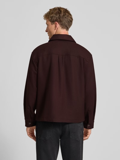 Männermodel trägt Jacke mit Brusttaschen Modell 'Atoka' von Carhartt Work In Progress, dunkles Braun, Baumwoll-Mix, Ganzkörperansicht Rückansicht.