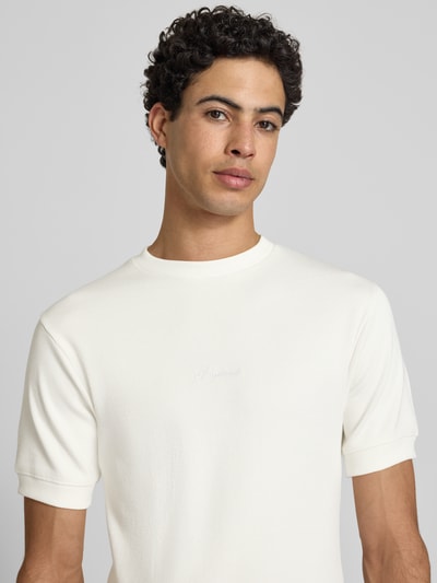 Männermodel trägt Slim Fit T-Shirt mit Label-Stitching von PROHIBITED in Weiß, Baumwoll-Elasthan-Mix, Rundhalsausschnitt, Nahaufnahme Oberkörper. Rückenlänge bei Größe M: 65 cm.