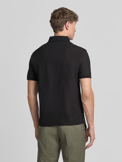 Männermodel trägt Slim Fit Poloshirt mit Strukturmuster von Emporio Armani, reine Baumwolle, verdeckte Knopfleiste, Rückansicht Ganzkörperansicht.