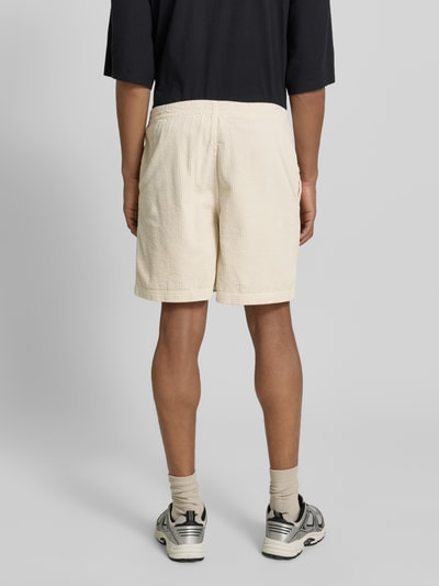 Männermodel trägt Shorts mit elastischem Bund Modell 'PADOW' von American Vintage, cremefarben, Baumwolle, lockerer Schnitt, Ganzkörperansicht Rückansicht.