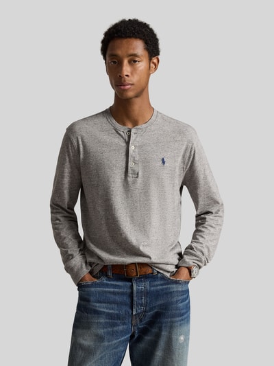 Männermodel trägt Regular Fit Langarmshirt aus reiner Baumwolle von Polo Ralph Lauren in Grau mit Holzkopfknöpfen, Ganzkörperansicht von vorne.