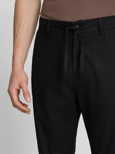 Männermodel trägt Relaxed Fit Hose aus Leinen-Baumwoll-Mix von s.Oliver RED LABEL, unifarben schwarz, Nahaufnahme Oberkörper.