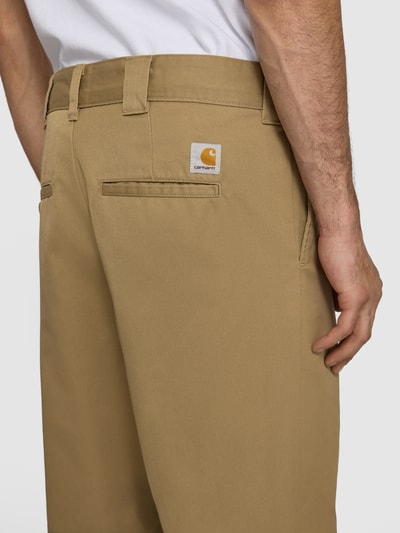 Männermodel trägt Hose mit Gesäßtaschen Modell 'Denison' von Carhartt Work In Progress in Beige aus Material-Mix, Nahaufnahme Rückansicht. Relaxed-Fit, Baumwoll-Anteil, Bundweite Größe 32: 46 cm, Innenbeinlänge 75 cm.