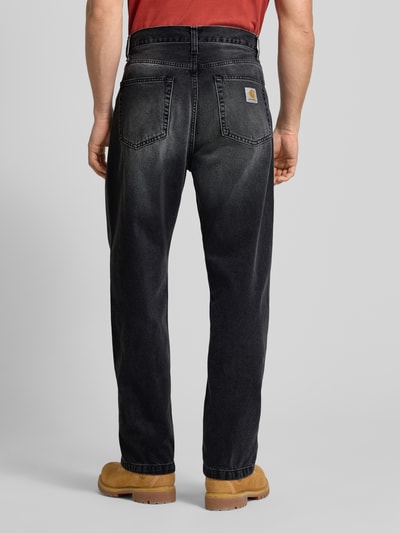 Männermodel trägt Jeans im 5-Pocket-Design Modell 'Landon' von Carhartt Work In Progress in Schwarz, gerade geschnitten, Rückansicht Ganzkörperansicht.