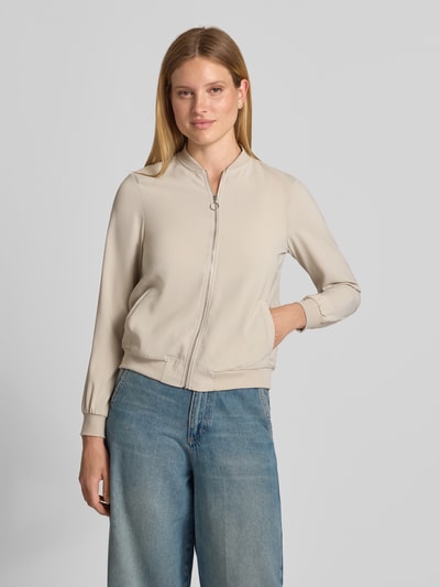 Frauenmodel trägt Regular Fit Blouson mit Allover-Muster Modell 'COCO' von VERO MODA in Beige, glatte Textur, lockere Passform, Ganzkörperansicht von vorne. Damen Bomberjacke / Blouson.