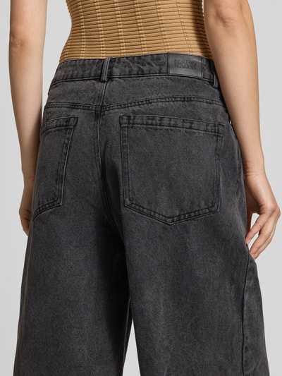Frauenmodel trägt Jeansshorts im Destroyed-Look von Karo Kauer in dunklem Grau mit Cut Out und Eingrifftaschen, Ganzkörperansicht Rückansicht. Kontext: Relaxed Fit, Bundweite bei Größe S 41 cm, Innenbeinlänge bei Größe S 37 cm.